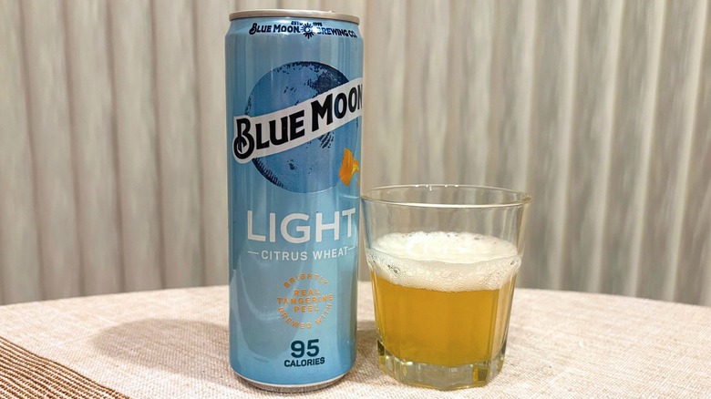 A can of Blue Moon Light next to a glass filled with beer