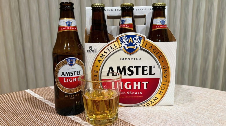 A package of Amstel Light next to an open bottle, with a glass of it in front of them