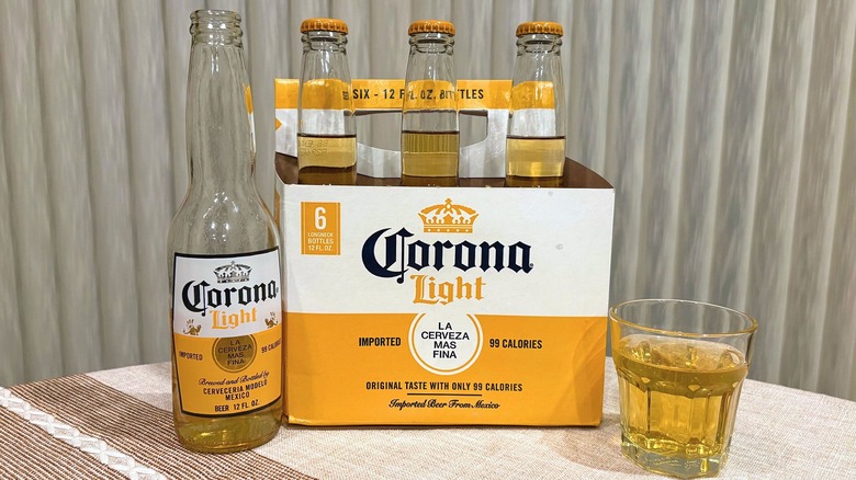 A bottle of Corona next to its package and a glass of Corona