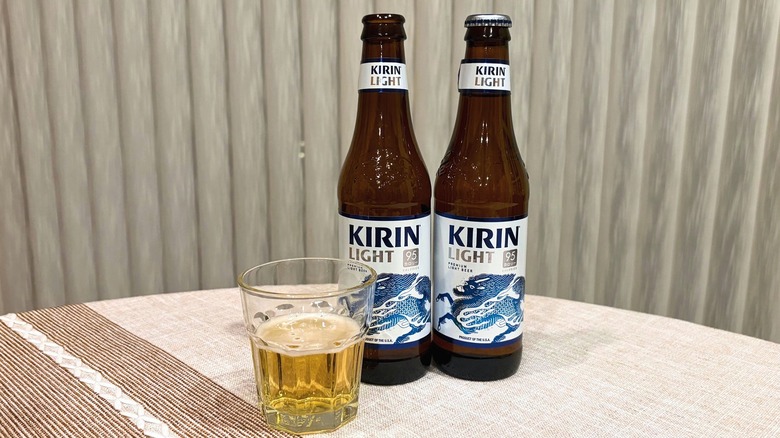 A glass of Kirin Light next to an open bottle and a closed bottle