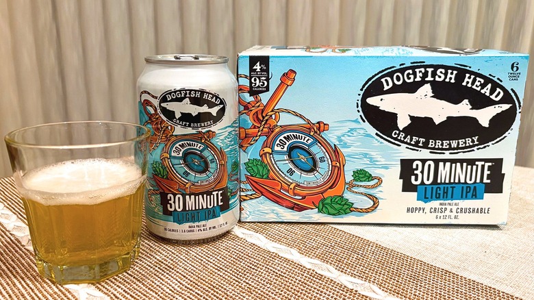 A glass of Dogfish Head 30 Minute Light IPA next to its can and the package