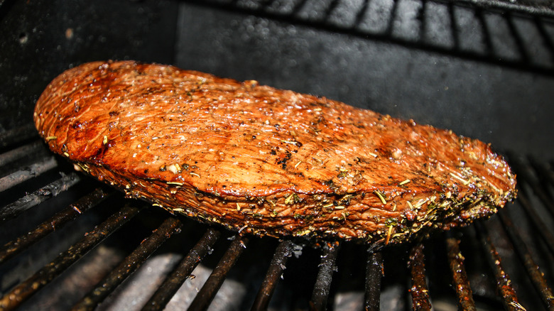 A well-done London broil on a grill