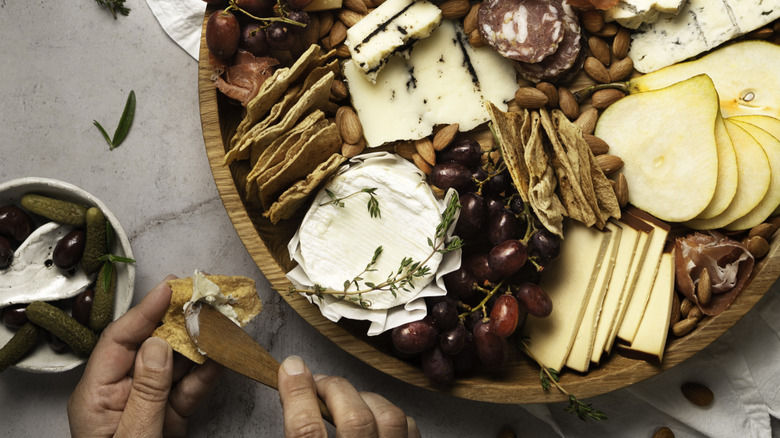 wooden tray filled with cheese and charcuterie