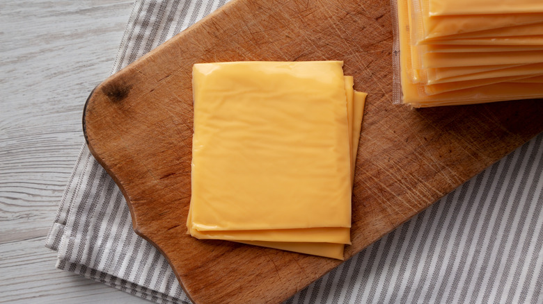 plain American cheese slices on wooden board