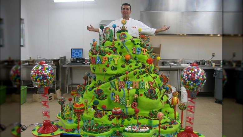 The Cake Boss standing behind a candy mountain cake