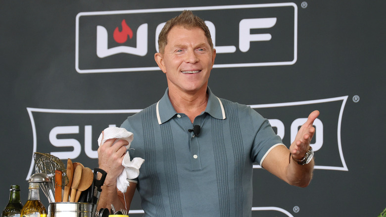Bobby Flay gestures to the audience during a cooking demonstrations