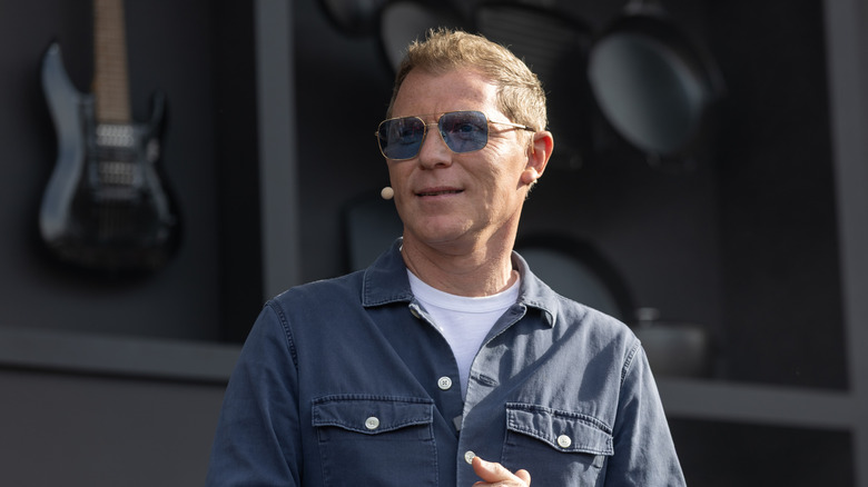 Bobby Flay speaking on stage at a cooking demonstration
