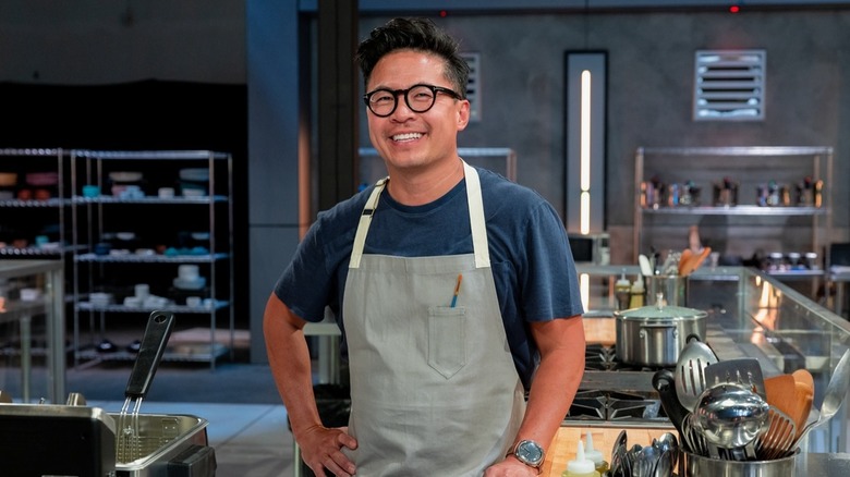 Viet Pham smiles while wearing a kitchen apron