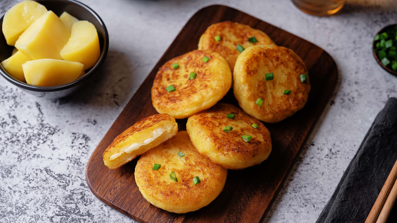 Fried potato cakes on a wooden cutting board