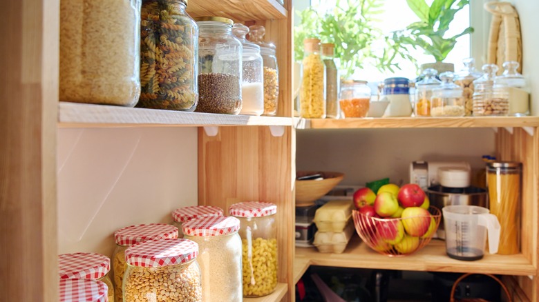 Full kitchen pantry with wooden shelves and sunlight streaming in