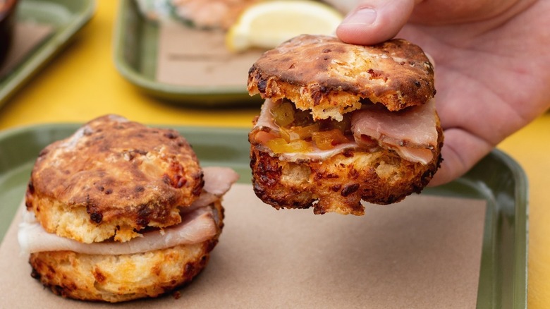 Hand holding biscuit sandwich