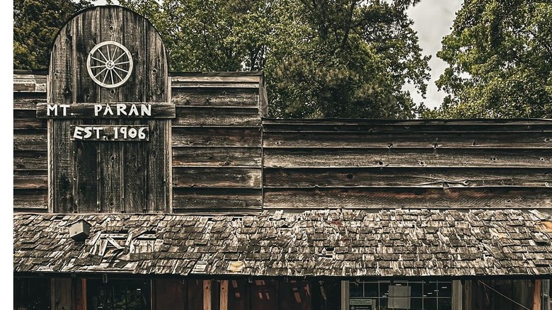 Man sitting outside old wooden store
