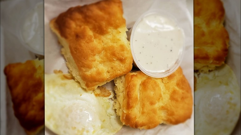 Biscuits and plastic cup of white gravy