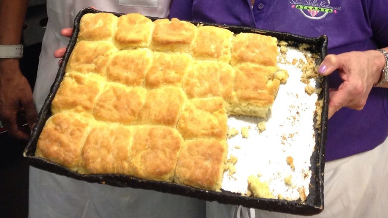 Woman holding tray of buttermilk biscuits