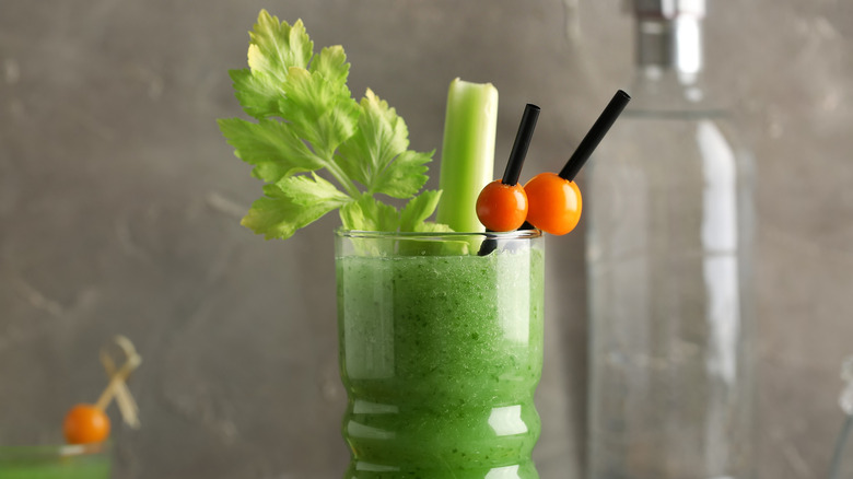 Green Bloody Mary with celery and tomato garnish