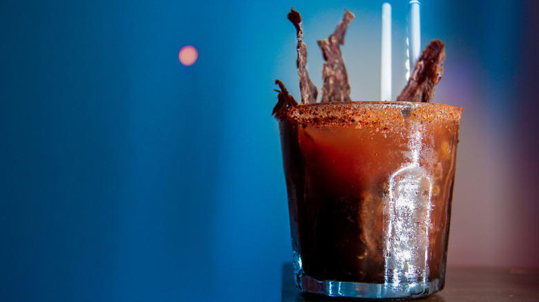 Red beer with seasoned rim and jerky garnish