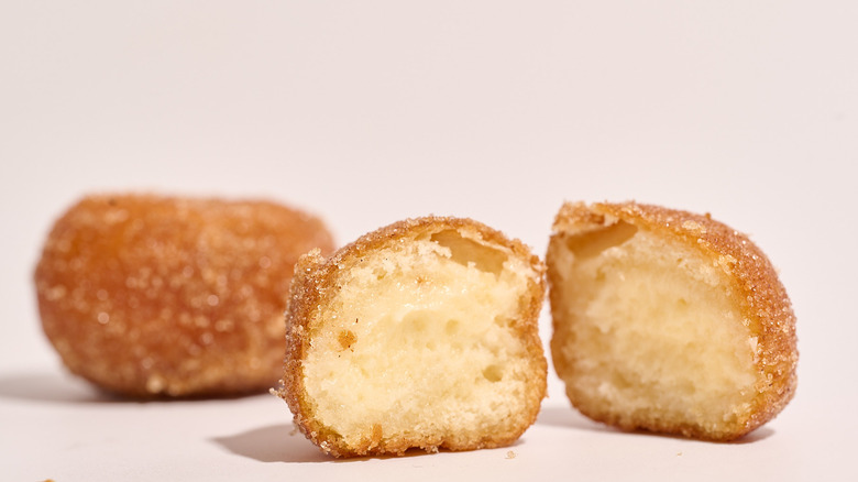 one whole and one halved Cinnabon Delights on a white table