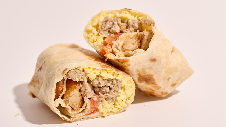 sausage breakfast burrito sliced in half on a table