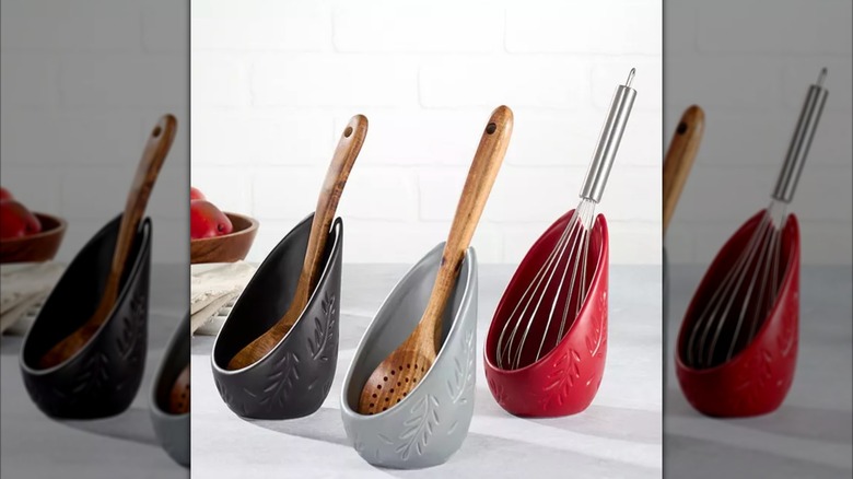 Three standing spoon rests holding various kitchen utensils on countertop.