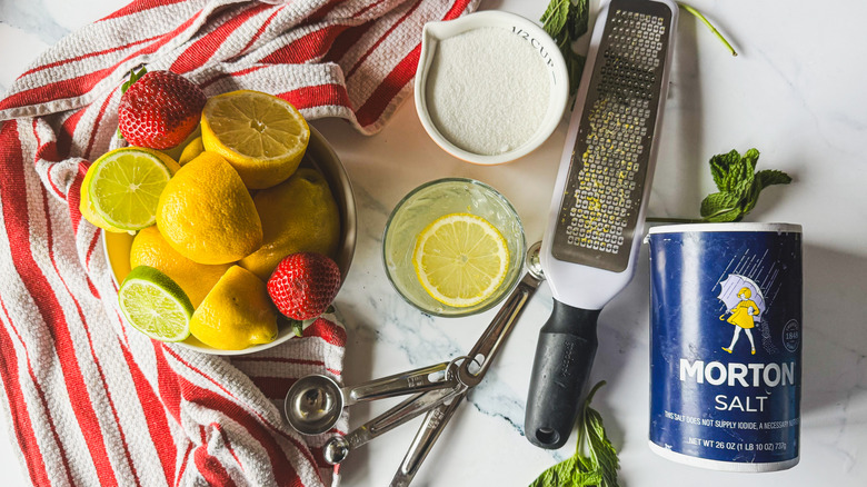Lemonade glass with salt, herbs, fruit, and measuring tools