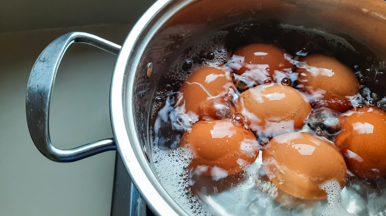 Brown eggs in bubbling water