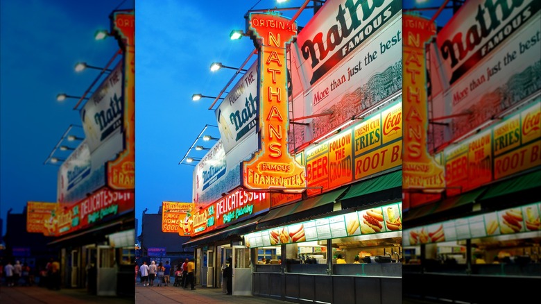 Illuminated signs in front of the original Nathan's Famous hot dog stand location