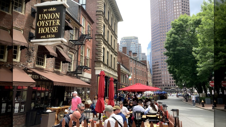 Diners sit outside of Union Oyster House at tables
