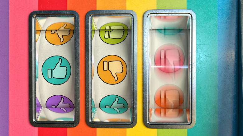 Three windows on a slot machine showing thumb's-up and thumb's-down graphics, with the righthand-most window still spinning