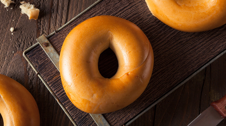 freshly made egg bagels on a wooden serving board