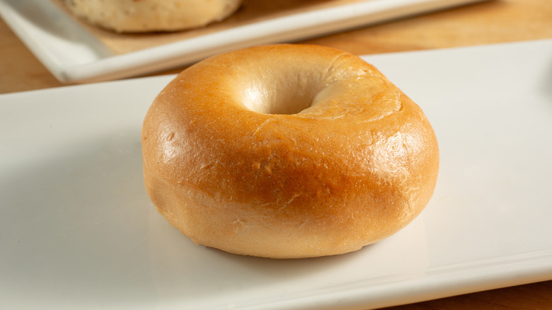 a plain bagel on a white plate