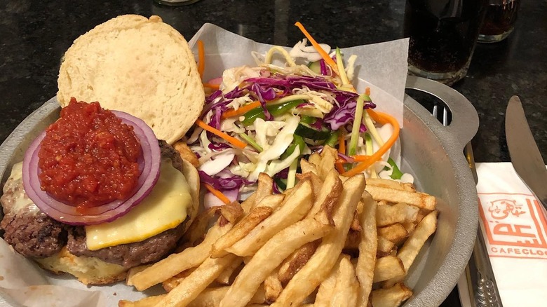 A camel burger on a plate with fries and coleslaw