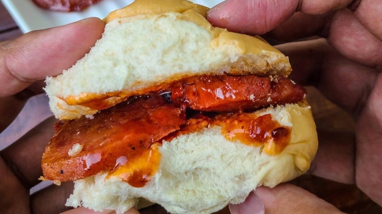 A person holding a chori burger on from Merly's BBQ Boracay