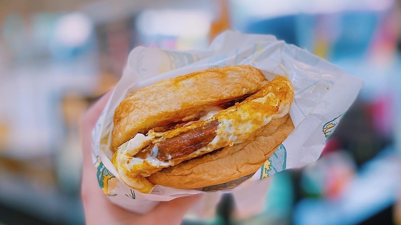 A person holding a ramly burger