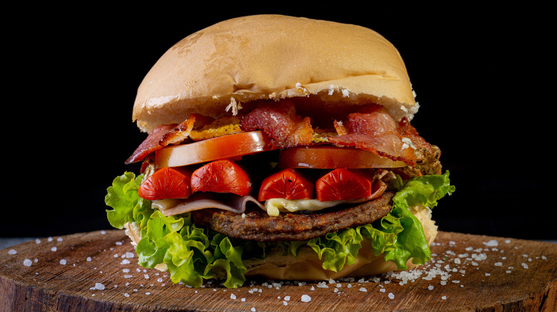 An X-Tudo burger on a wooden cutting board