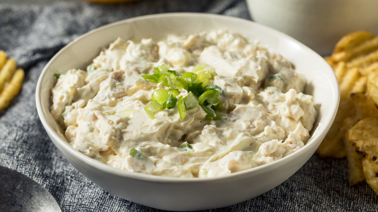 A bowl of clam dip with potato chips