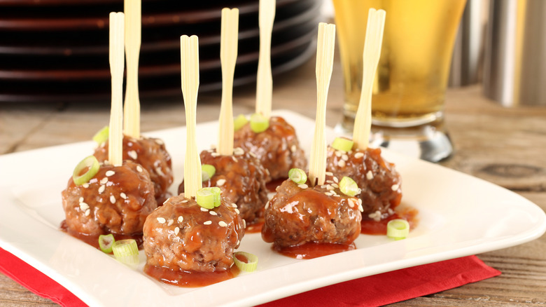 Cocktail meatballs on a plate with wooden skewers