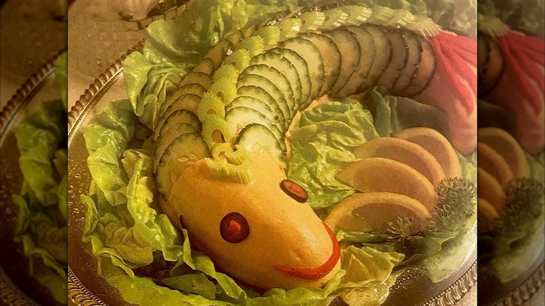 A fish-shaped salmon mousse with cucumbers and olives for eyes