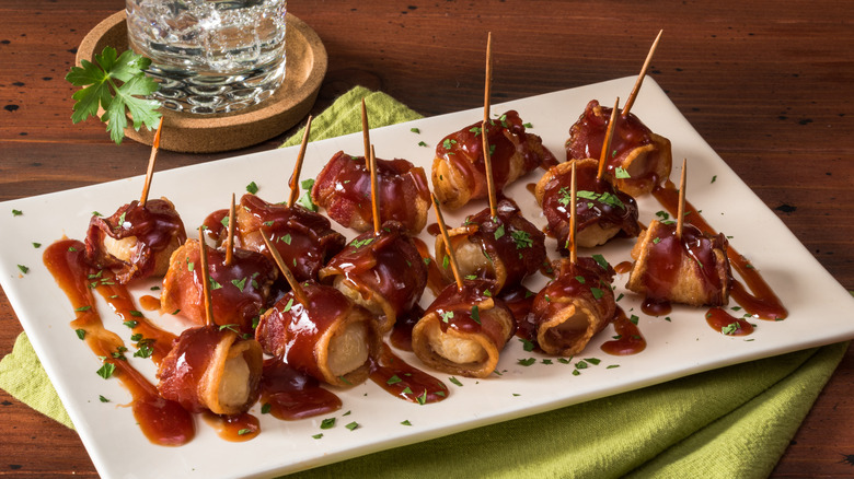 A plate of rumaki with toothpicks on a plate