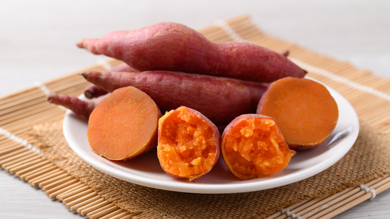sweet potatoes on a plate, some of them cut in half