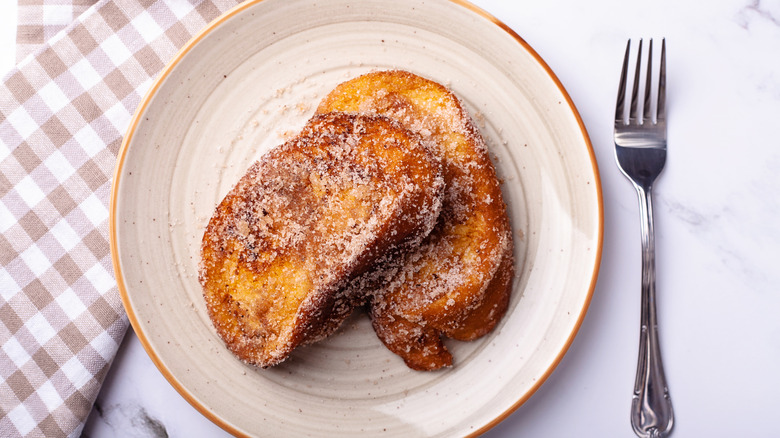 two slices of French toast with powdered sugar on a white plate