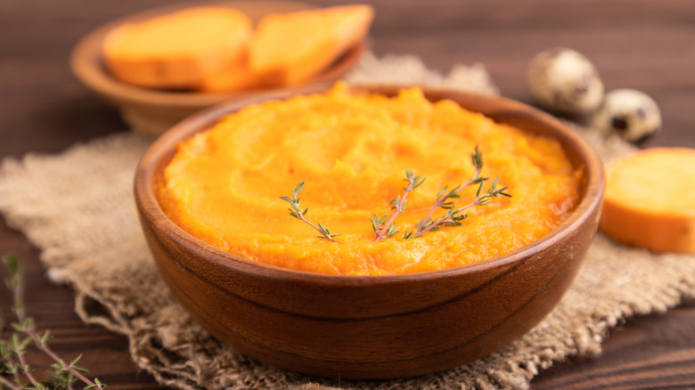 a plain mashed sweet potato oatmeal in a wooden bowl