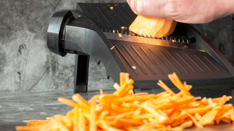 a person shredding sweet potatoes for use in hash browns