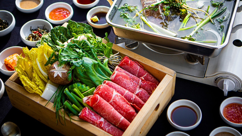shabu shabu with vegetables, meat, and sauces