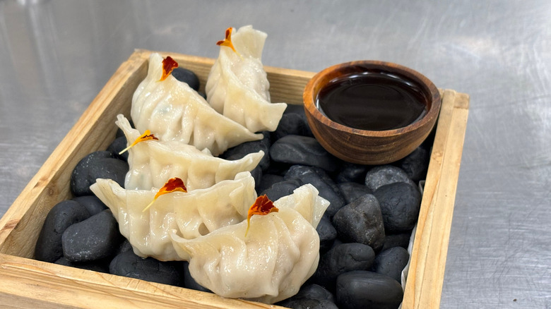 gyoza served on a plate with ponzu sauce