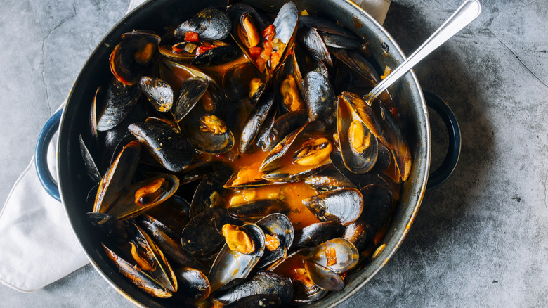 cooked mussels in pot with spoon