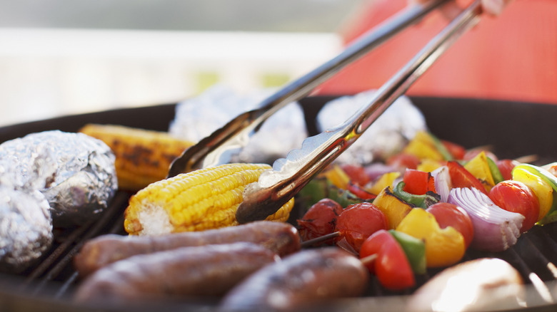 Vegetables a grill with barbecue tongs