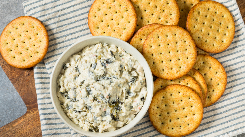 Bowl of spinach and artichoke dip with crackers