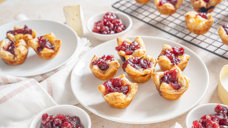 Brie and cranberry puff pastry bites, served on a white plate