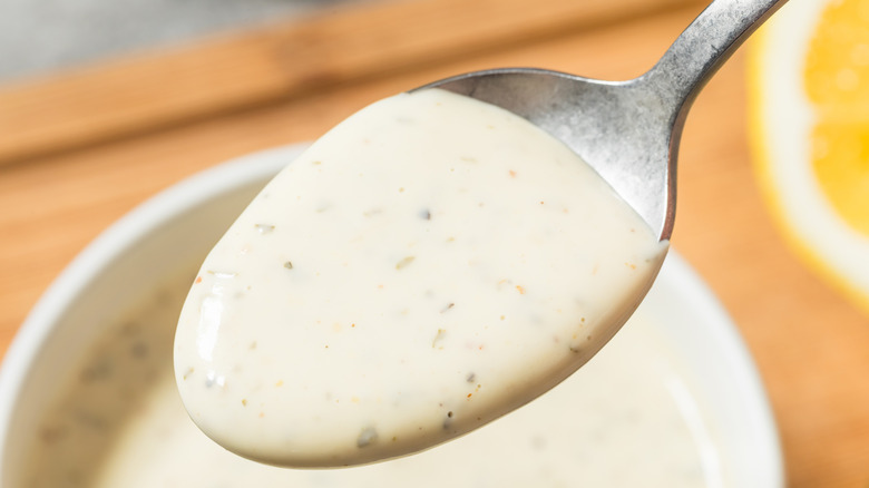 A spoonful of homemade ranch dressing out of a bowl