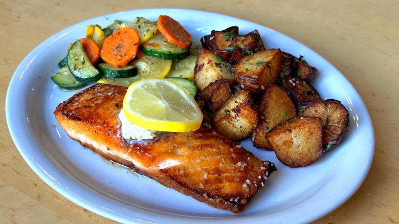 A plate of salmon with potatoes and vegetables at Hollerbach's German Restaurant